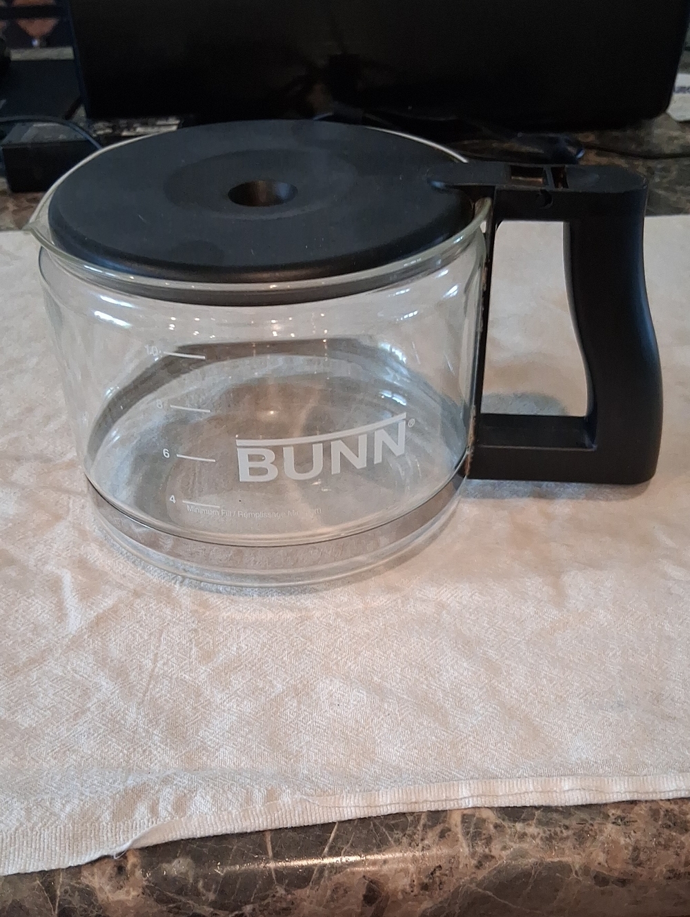 Bunn 10-cup replacement‎ glass carafe featuring a black lid and handle.